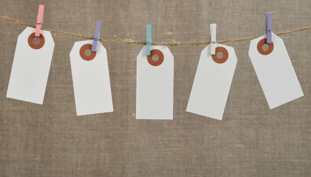 Des étiquettes blanches accrochées sur une corde, avec des pinces à linge de couleur